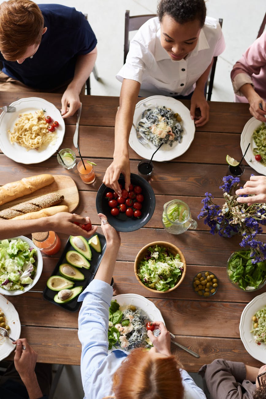 a group of six friends enjoying dinner around a table